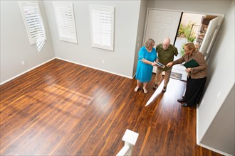 Female real estate agent showing senior adult couple A new home