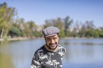 Bearded mature man wearing a beret at a lake. Copy space