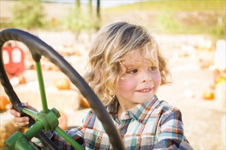 Little boy having fun in A tractor in a rustic ranch setting at the pumpkin patch