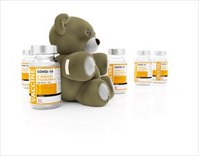 COVID-19 vaccine for children vials and teddy bear with bandage on white background