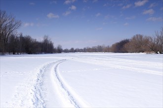 Snow vehicle tracks on a frozen river surface