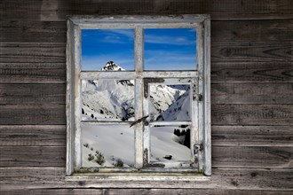 View through a rustic wooden window of the Lechtal Alps