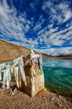 Small gompa with buddhist prayer flags at sacred Dhankar Lake in Himalayas. Spiti Valley