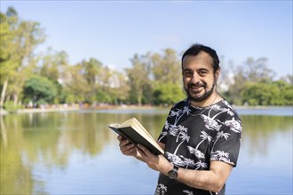 Mature man reading by a lake