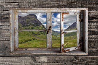 View through a rustic wooden window into the Glen Coe valley