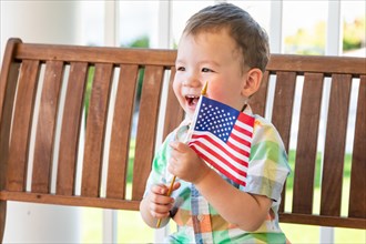 Young mixed-race chinese and caucasian boy playing with american flag