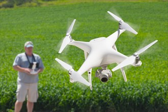 Pilot flying unmanned aircraft drone gathering data over country farmland field