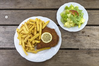Cordon bleu with french fries and salad plate served in an inn