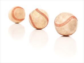 Three baseballs isolated on a reflective white background