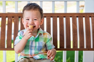 Young mixed-race chinese and caucasian boy enjoying his ice cream cone