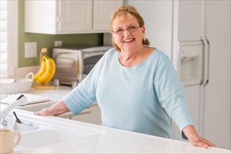 Portrait of A beautiful smiling senior adult woman in kitchen