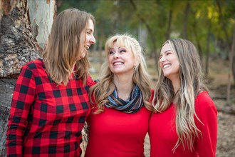 Beautiful mother and young adult daughters portrait outdoors