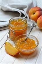 Peach jam in glass bowl and peaches