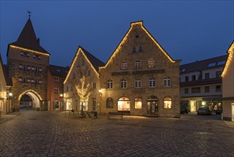 Historic gabled houses and the Hersbruck Gate with Christmas lighting on the market square in the evening