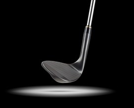 Black golf club wedge iron under spot light with black background