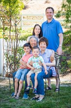 Chinese and caucasian family sitting on bench