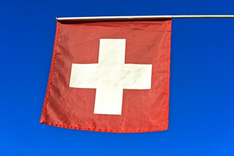 Schweizer Flagge gegen blauen Hintergrund