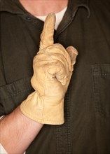 Man with leather construction glove and number one hand gesture