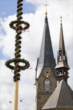 Maypole on the main square with town parish church and town hall