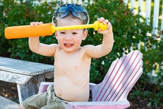 Happy playful young mixed-race chinese and caucasian boy wearing swimming goggles