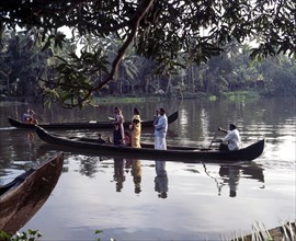 People being taken in a boat across the back waters of Alappuzha or Alleppey in Kerala