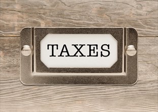 Taxes metal file label frame on wood background