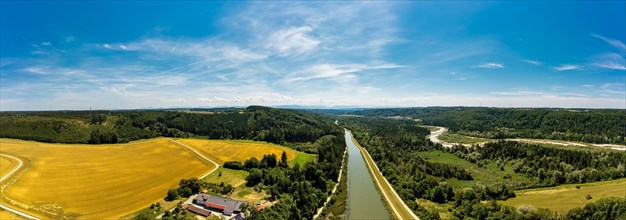 The Isar flowing towards the distant Alps with adjacent yellow rape field near Schaeftlarn