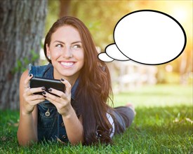 Thoughtful young woman with cell phone and blank thought bubble