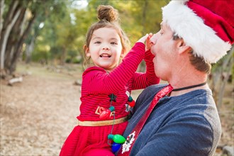 Festive grandfather and mixed-race baby girl outdoors