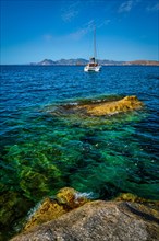 Yacht boat in Aegean sea at white rocks of Sarakiniko Beach