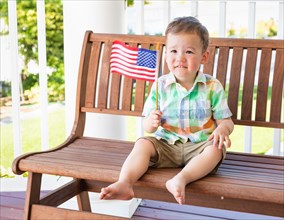 Young mixed-race chinese and caucasian boy playing with american flag