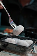 Delicious. Mochi on a fork in a restaurant