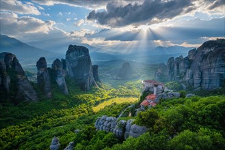Sunset over monastery of Rousanou and Monastery of St. Nicholas Anapavsa in famous greek tourist destination Meteora in Greece on sunset with sun rays and lens flare and dramatic sky