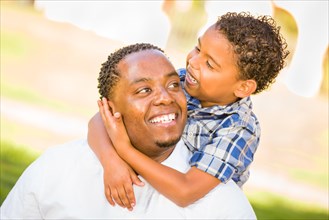 Happy african american father and mixed-race son playing at the park