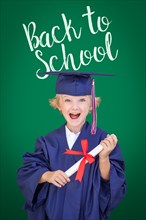 Young caucasian boy in graduation cap and gown against green chalkboard background with back to school