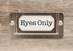 Eyes only metal file label frame on wood background