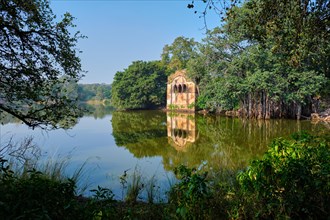 Beautiful toursit landmark Padma Talao lake with ruins remnants of fort. Tropical green and trees of reserve. Ranthambore National Park