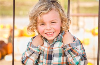 Little boy having fun in a rustic ranch setting at the pumpkin patch