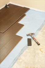 Hammer and block with new laminate flooring abstract