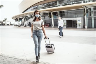A young woman leaving the airport with her luggage ready to discover a new destination