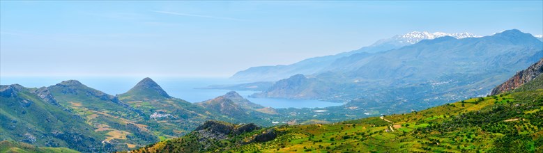 Panorama view of Crete island in Greece with green fields and wineries and flock of sheep grazing