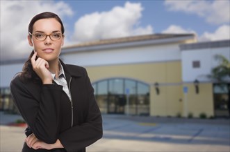 Attractive serious mixed-race woman in front of vacant commercial retail building