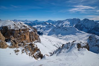 View of a ski resort ski slope and Dolomites mountains in Italy from Passo Pordoi pass