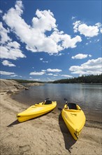Pair of yellow kayaks on a beautiful mountain lake shore