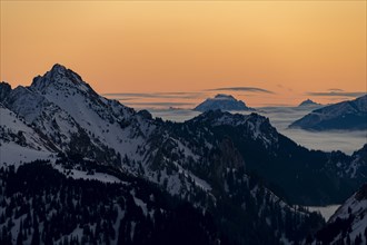 Winterliche Gipfel der Ammergauer Alpen bei Sonnenaufgang mit Nebelmeer