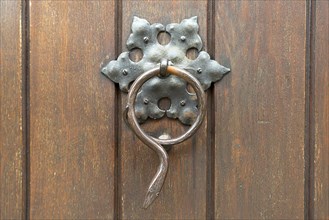 Snake figure as a door knocker on the door of a parish