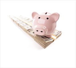 Pink piggy bank on row of hundreds of dollars stacks isolated on a white background
