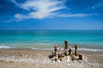 Concept of balance and harmony. Stones pebbles stacks on the beach coast of the blue sea in the nature. Meditative art of stone stacking