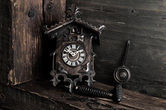 Antique Black Forest cuckoo clock on wooden background