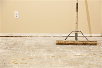 Blank concrete house floor with broom ready for flooring installation